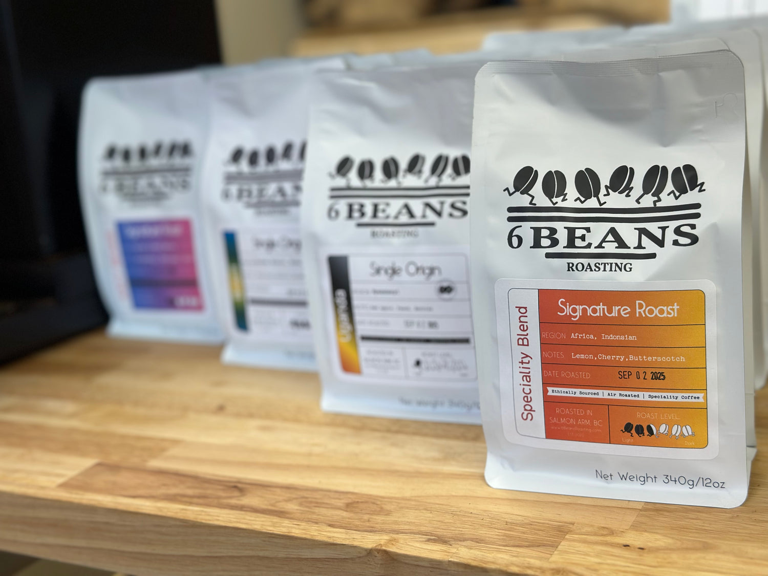 Packages of 6 Beans Roasting coffee on a wooden surface